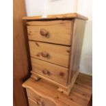 A modern pine bedside chest of three drawers