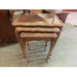 A reproduction walnut nest of three tables