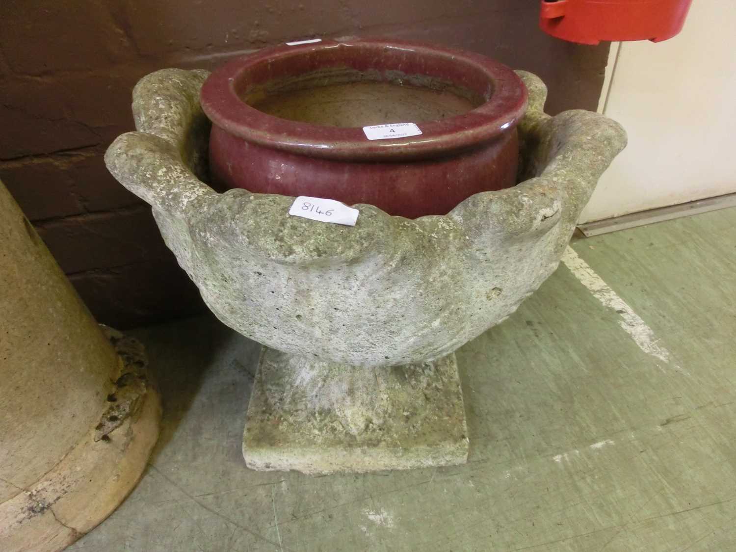 A red glazed garden pot along with a composite stone garden pot