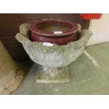 A red glazed garden pot along with a composite stone garden pot