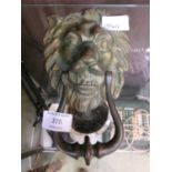 A cast brass door knocker in the form of lion