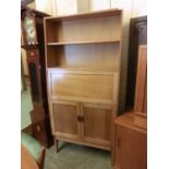 A mid-20th century oak veneered bookcase/bureau , open storage above fall front and cupboard doors