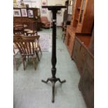 An early 20th century mahogany torchere stand, circular top over reeded column on three swept legs