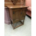 A reproduction oak bedside cabinet with Gothic arch panelled doors