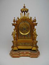 A late 19th century French brass and polychrome mantle clock, the face with Roman numerals flanked