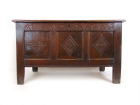 A late 17th century oak coffer, the three panel top lifting to reveal a vacant interior with
