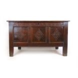 A late 17th century oak coffer, the three panel top lifting to reveal a vacant interior with