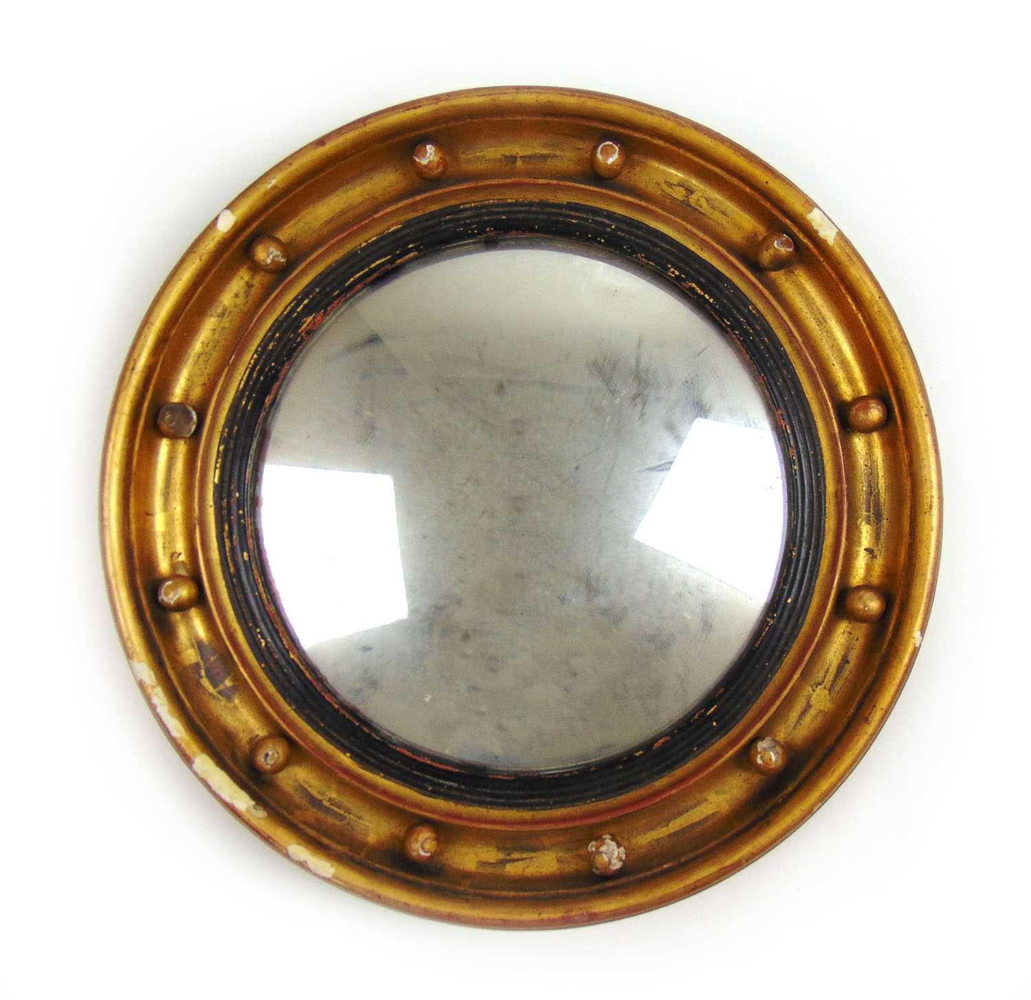 A Regency gilt wood convex mirror. the moulded frame with spheres surrounding the circular plate,