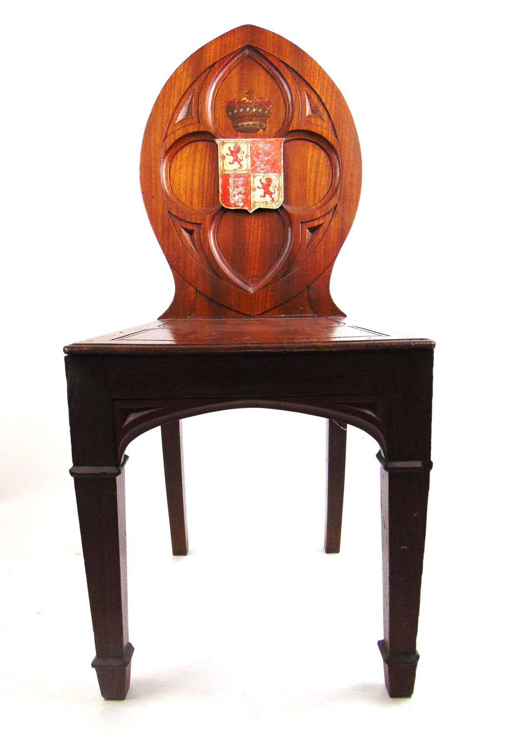 An early 19th century mahogany Gothic hall chair, the carved quatrefoil back with armorial shield