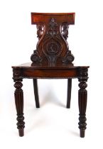 An early 19th century mahogany hall chair in the style of Gillows, the carved back over the banded