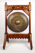 A 19th century gothic oak gong, the pierced, chamfered and polychrome frame holding the hammered