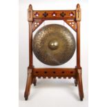 A 19th century gothic oak gong, the pierced, chamfered and polychrome frame holding the hammered
