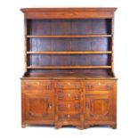 An 18th oak, mahogany and inlaid dresser, the plate rack with fixed shelves flanked by split