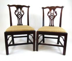 A pair of 18th century mahogany dining chairs, the pierced splat over the pad seats upholstered in a