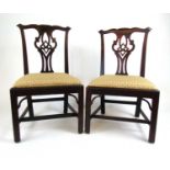 A pair of 18th century mahogany dining chairs, the pierced splat over the pad seats upholstered in a