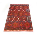 A modern handwoven Turkish rug, the border surrounding the red ground field with geometric design,