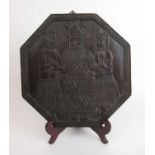 A 20th century Benin carved octagonal wooden plaque depicting three figures, w. 31 cm