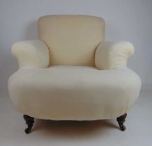 An Edwardian walnut Howard style armchair, upholstered in calico on ceramic castors, h. 62 cm, w. 86