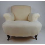 An Edwardian walnut Howard style armchair, upholstered in calico on ceramic castors, h. 62 cm, w. 86
