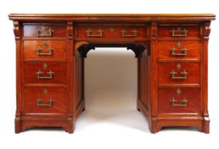 A late Victorian oak free standing twin pedestal desk, the top with a brown tooled leather insert
