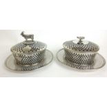 A pair of Victorian silver reticulated butter dishes and stands. One dish with goat finial and
