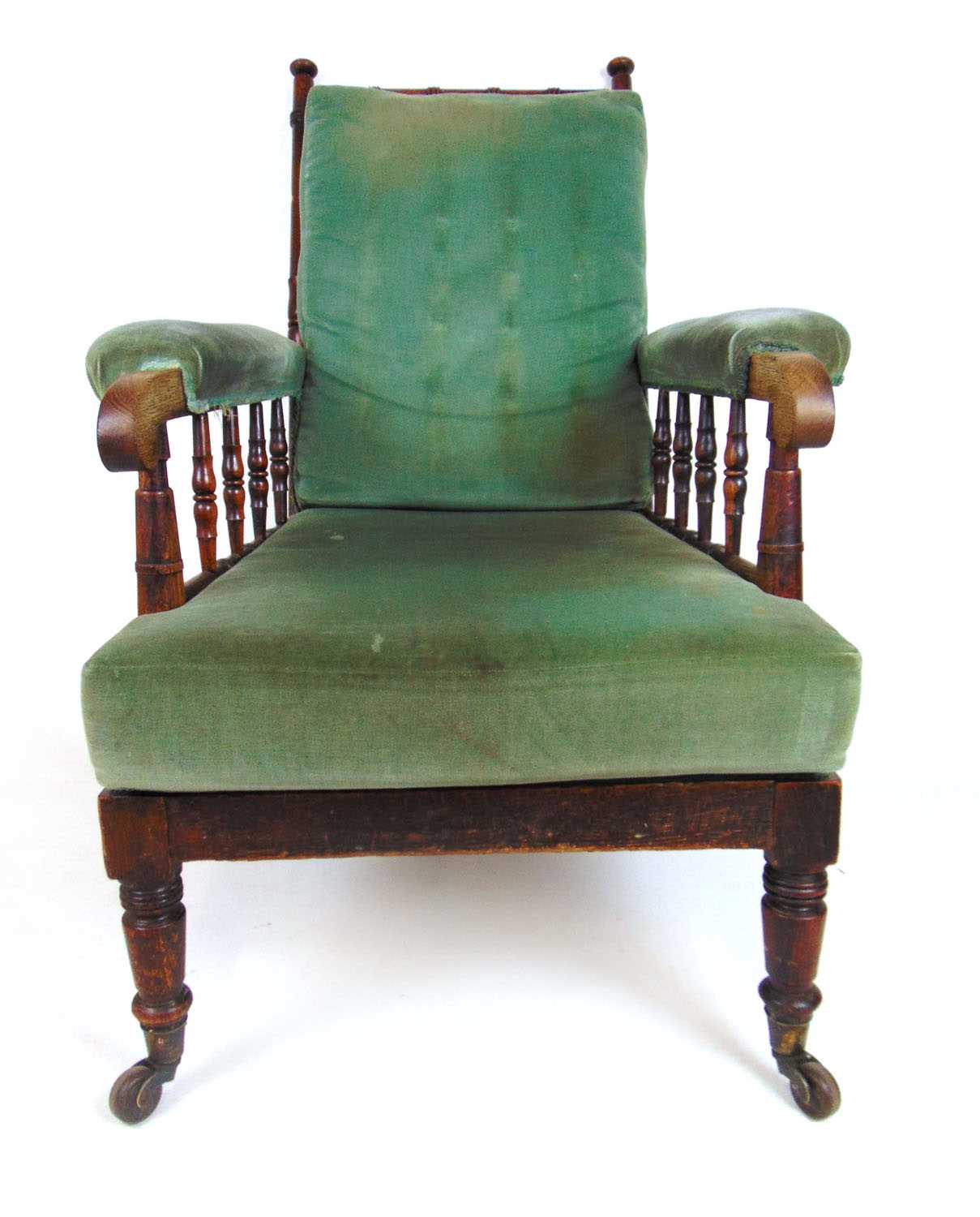 An early 19th century oak armchair upholstered in a cut green fabric, the turned frame on turned