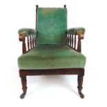 An early 19th century oak armchair upholstered in a cut green fabric, the turned frame on turned