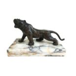 A 20th century bronze model of a roaring tiger mounted on a white marble plinth. Unsigned, h. 10 cm