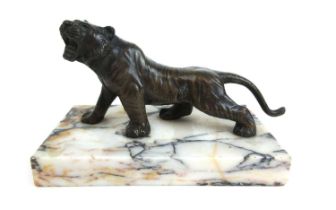A 20th century bronze model of a roaring tiger mounted on a white marble plinth. Unsigned, h. 10 cm