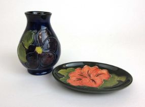 A small Moorcroft baluster vase decorated in the clematis pattern on a blue ground together with a