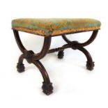 An early 19th century rosewood X-frame stool, the floral needlework seat over the moulded frame with