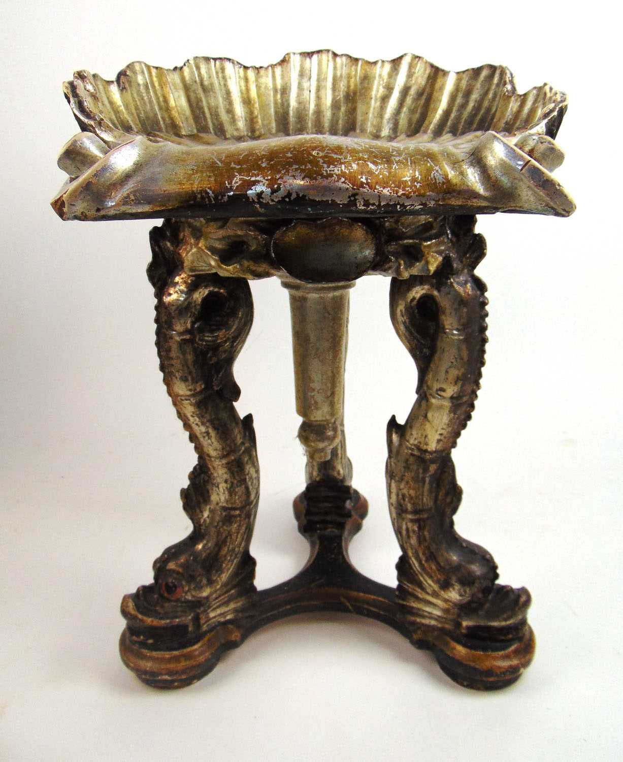 An early 20th century silvered grotto stool, the shell seat supported on three dolphin legs, h. 57