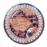 A large 19th century Japanese porcelain charger decorated in the imari pallet with a reticulated