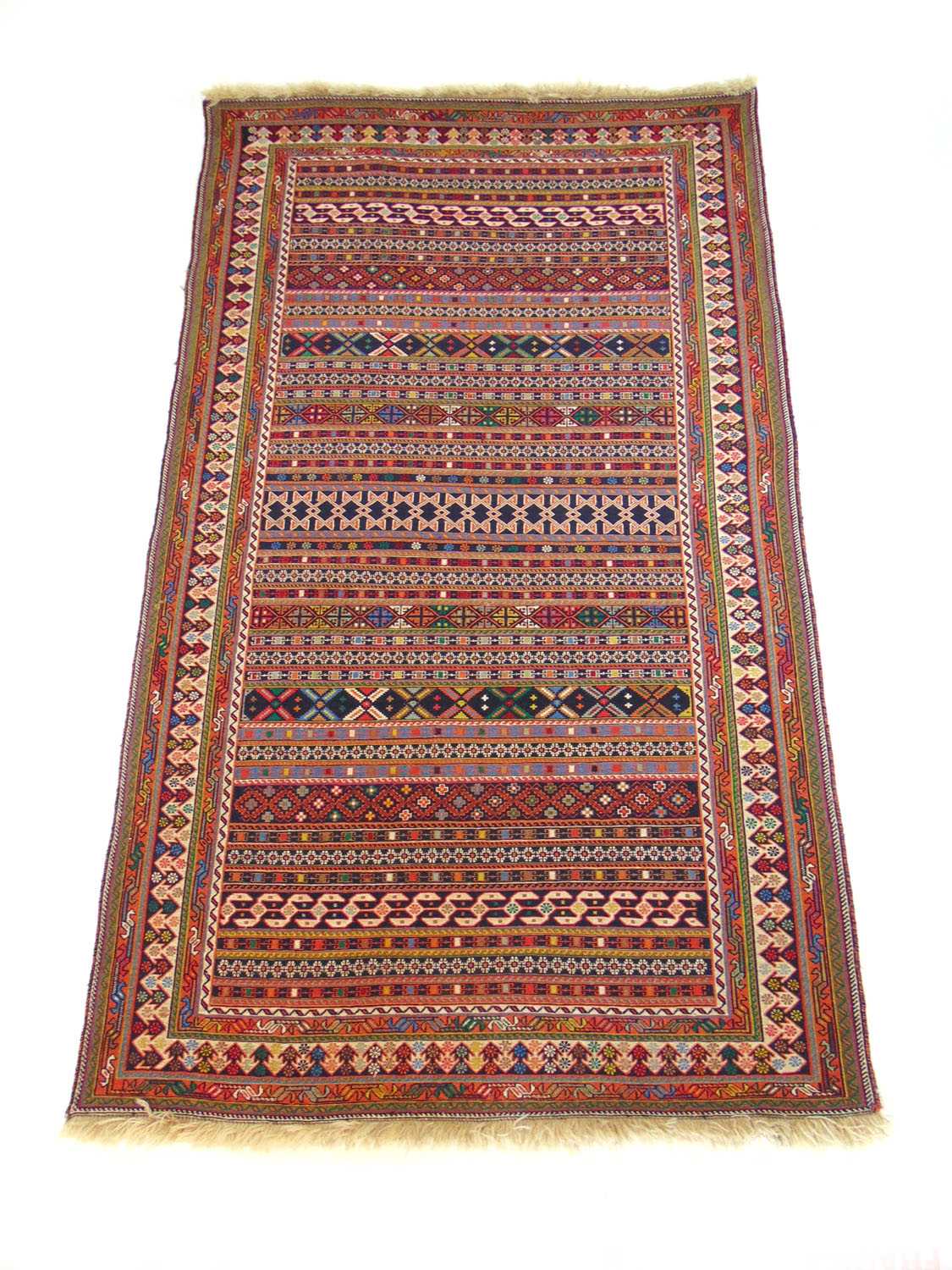 A handwoven Persian (?) rug, the multi line border surrounding the striped field, 214 cm x 128 cm