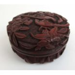 A Chinese cinnabar lacquered scholars seal paste pot carved in relief with birds amidst foliage.