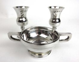 A George V silver twin handled cup or quaich together with two small Elizabeth II silver goblets.