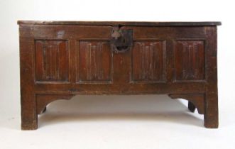 A 17th century oak coffer, the top lifting to reveal a vacant interior with candle box over the four