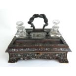 A 19th century tortoiseshell and mother of pearl inlaid desk stand incorporating two inkwells and