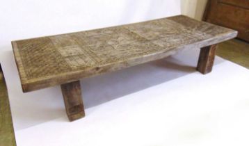 A South American carved hardwood coffee table, the top with two carved bird panels surrounded by