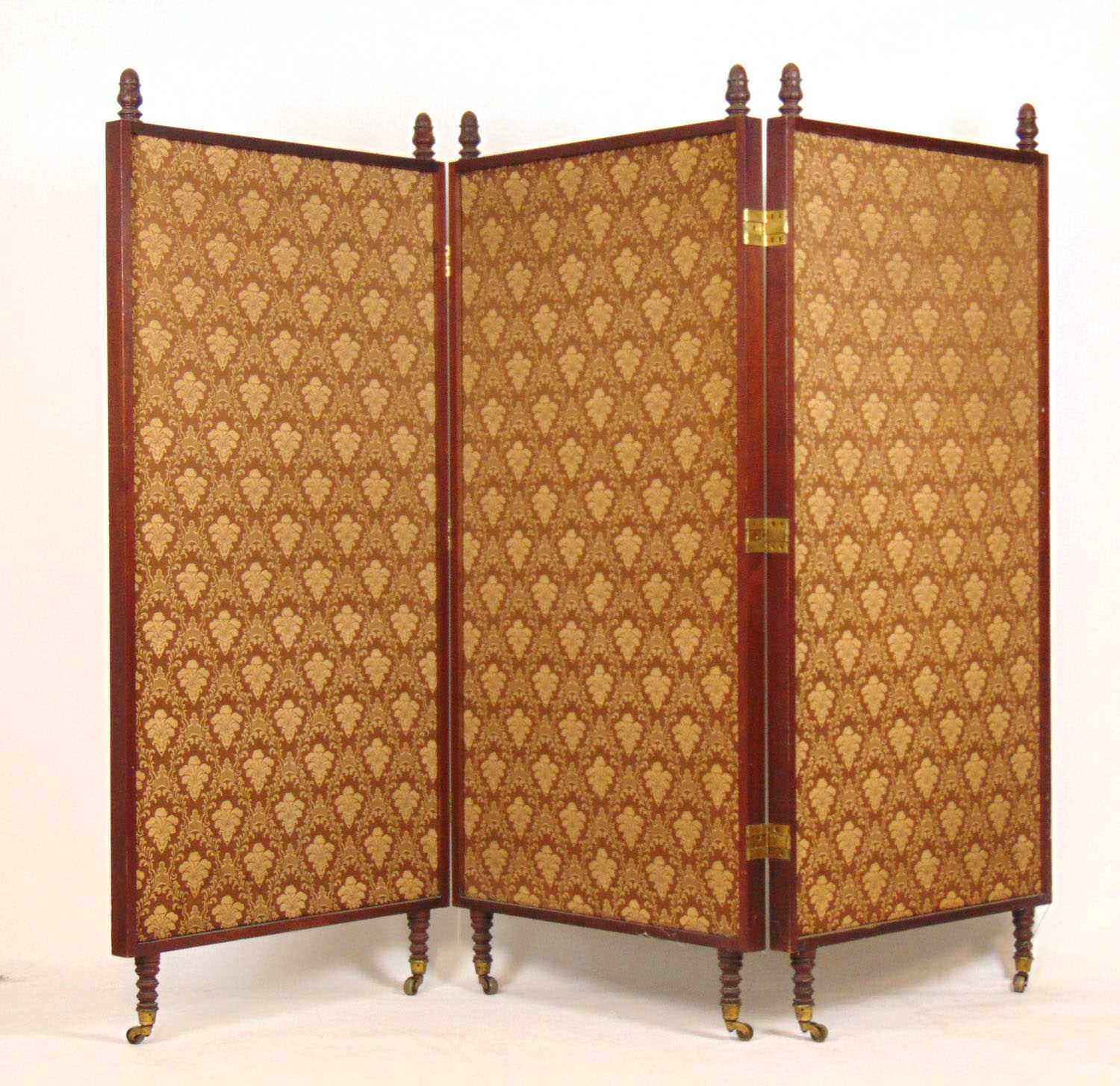 A 19th century walnut three fold screen, the finials over patterned fabric panels on turned feet and