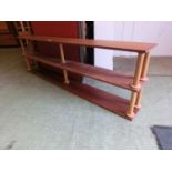 A three tier teak veneered open bookcase with bobbin supports