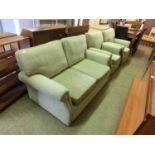 A three piece suite comprising of a two seater settee and two armchairs upholstered in a cut green