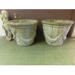 A pair of garden urns with swag design to body