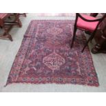 A hand woven caucasian rug, the multi line border enclosing a blue ground field with animal motif