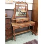 An Edwardian walnut dressing table, the bevelled plate over trinket drawers, the base with two