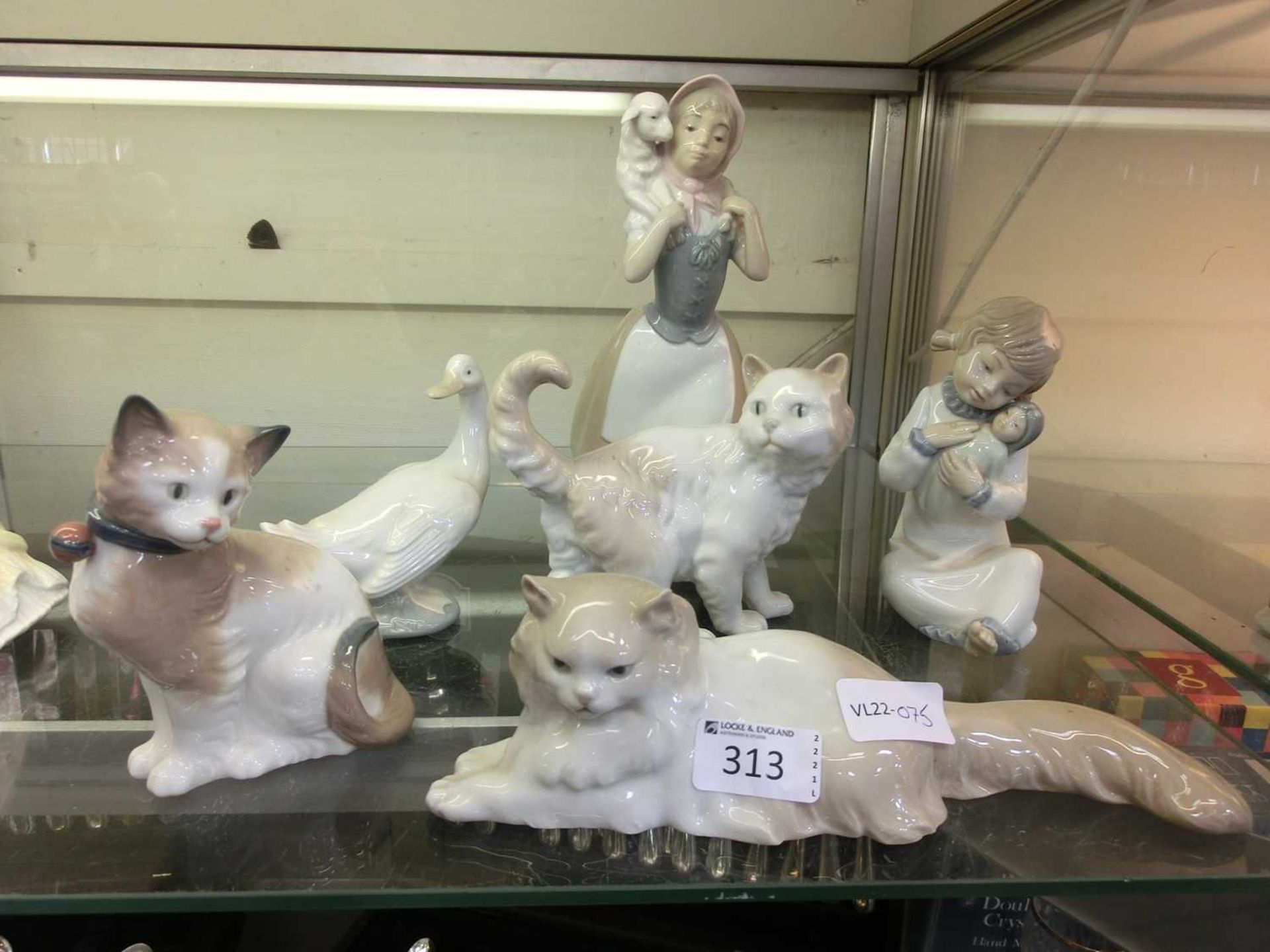 A selection of Nao figurines to include cats, duck, and young children