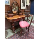 A 19th century mahogany dressing table, the oval mirror over trinket drawers on a bow front base