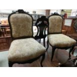 A pair of carved mahogany dining chairs having overstuffed seats and backs