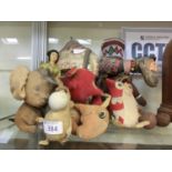 A collection of early 20th century soft toys to include camel, dolls, owl, etc