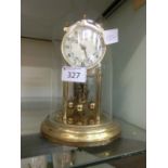 A reproduction brass effect anniversary clock with dome